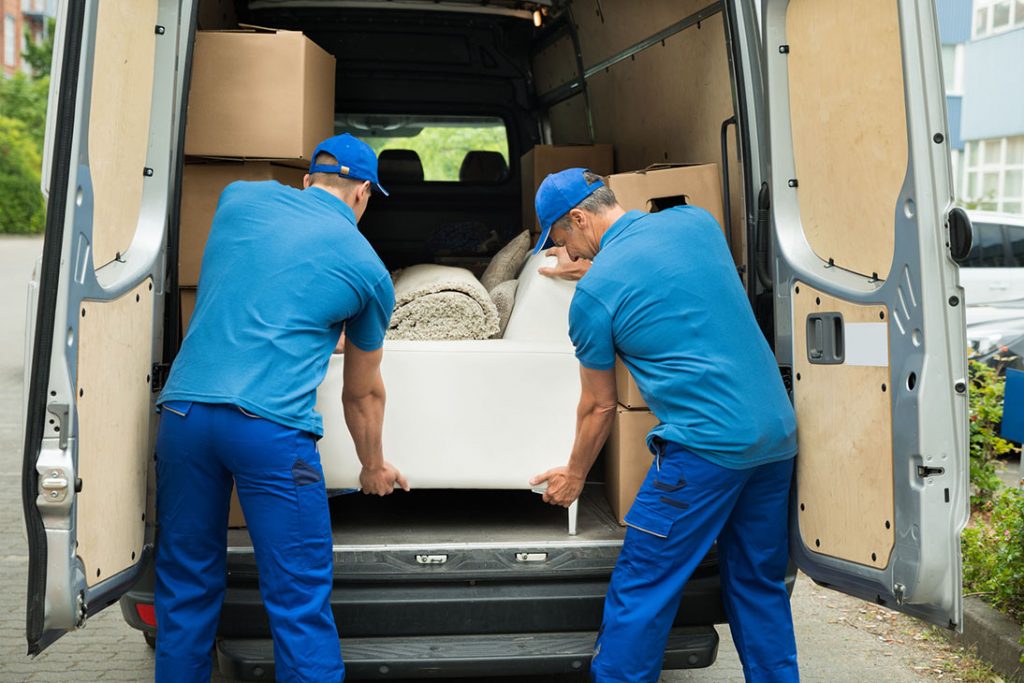 Two Workers Adjusting Sofa In Truck - Paris Débarras